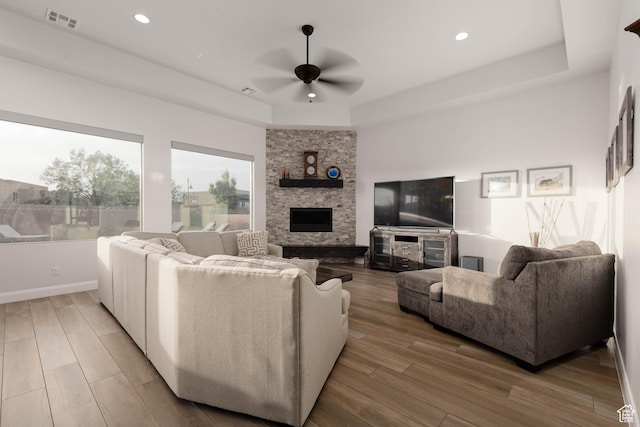 3318 S Red Rock Way, Hurricane, UT 84737 - living area featuring a tray ceiling, light wood-style flooring, visible vents, a ceiling fan, and a fireplace