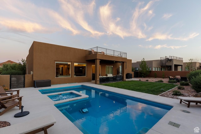3318 S Red Rock Way, Hurricane, UT 84737 - pool at dusk featuring a patio, a pool with connected hot tub, and a yard