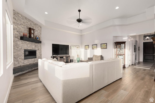 3318 S Red Rock Way, Hurricane, UT 84737 - living room with a stone fireplace, baseboards, light wood-style floors, and ceiling fan