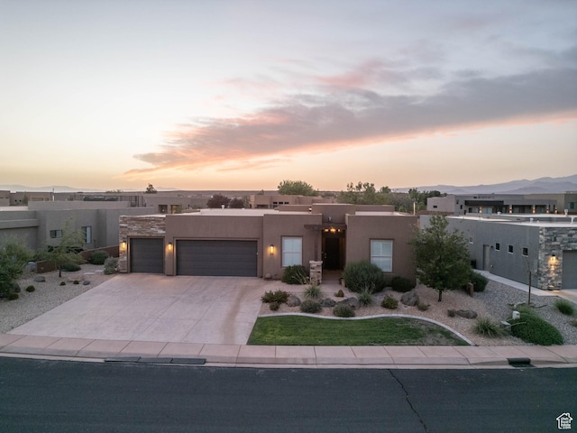 3318 S Red Rock Way, Hurricane, UT 84737 - pueblo-style home featuring stucco siding, an attached garage, and concrete driveway