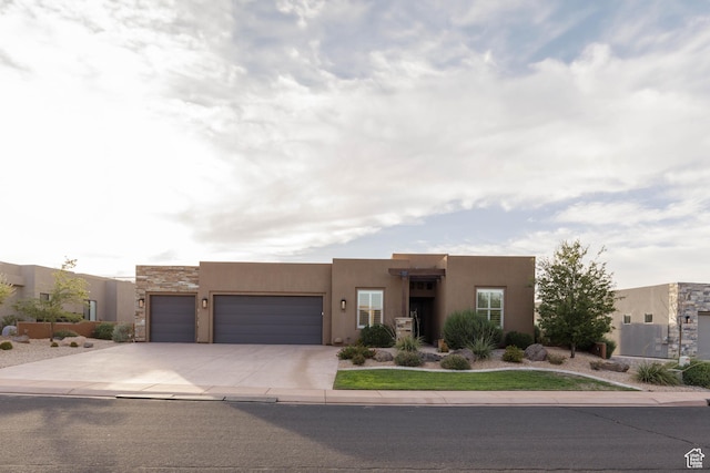 3318 S Red Rock Way, Hurricane, UT 84737 - pueblo-style house featuring a garage, driveway, and stucco siding