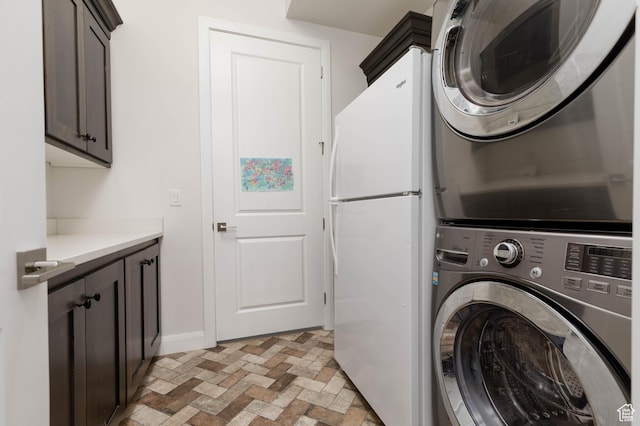 3318 S Red Rock Way, Hurricane, UT 84737 - laundry room with stacked washer and clothes dryer, cabinet space, brick floor, and baseboards