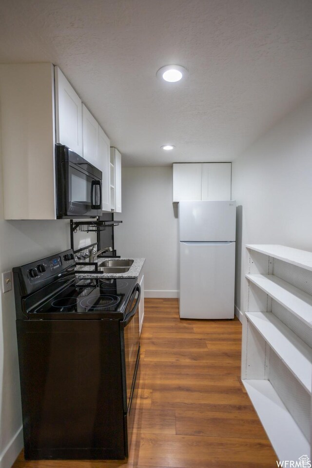 4424 W Skye Dr, South Jordan, UT 84009 - kitchen featuring baseboards, a sink, black appliances, white cabinetry, and wood finished floors