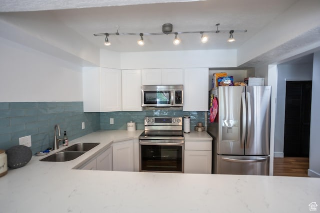 4424 W Skye Dr, South Jordan, UT 84009 - kitchen with white cabinets, a sink, stainless steel appliances, backsplash, and light stone counters