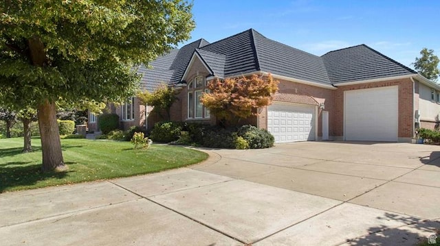 643 W Ridgewood Cir, Farmington, UT 84025 - view of front of home with brick siding, a front yard, driveway, and an attached garage