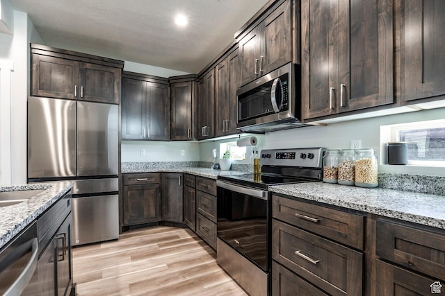 668 S 400 E, Clearfield, UT 84015 - kitchen with appliances with stainless steel finishes, dark brown cabinetry, light stone countertops, and recessed lighting