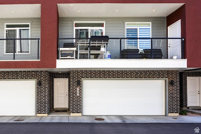 668 S 400 E, Clearfield, UT 84015 - view of front of property with an attached garage, a balcony, and brick siding