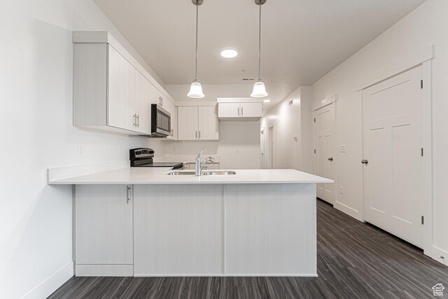 4718 W Neill Ln Unit Mm303, Riverton, UT 84096 - kitchen with light countertops, a sink, dark wood-style floors, a peninsula, and appliances with stainless steel finishes