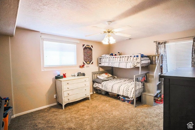 carpeted bedroom with baseboards, a textured ceiling, and ceiling fan