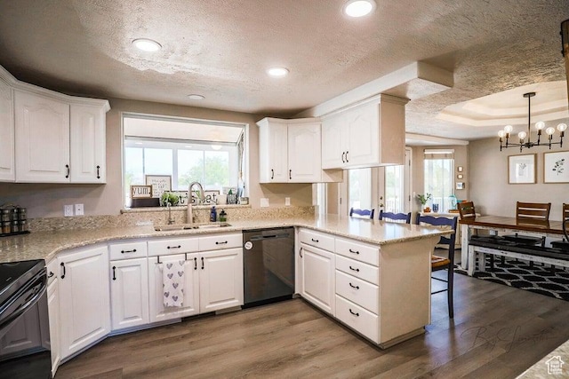 kitchen featuring a sink, white cabinets, black appliances, and a peninsula