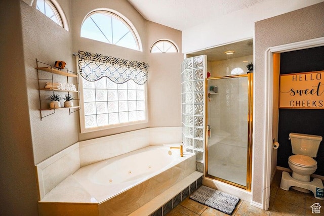 full bath with a jetted tub, tile patterned floors, a shower stall, and toilet