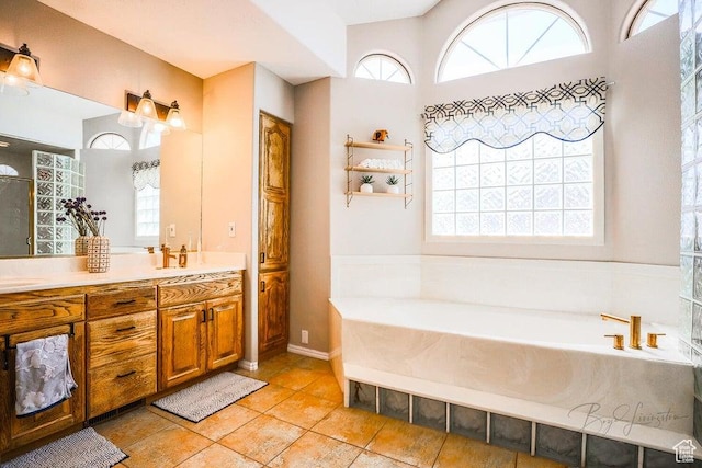 bathroom with double vanity, tile patterned floors, and a garden tub
