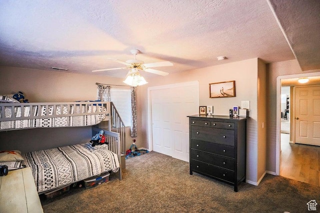 bedroom featuring carpet flooring, a textured ceiling, and a ceiling fan