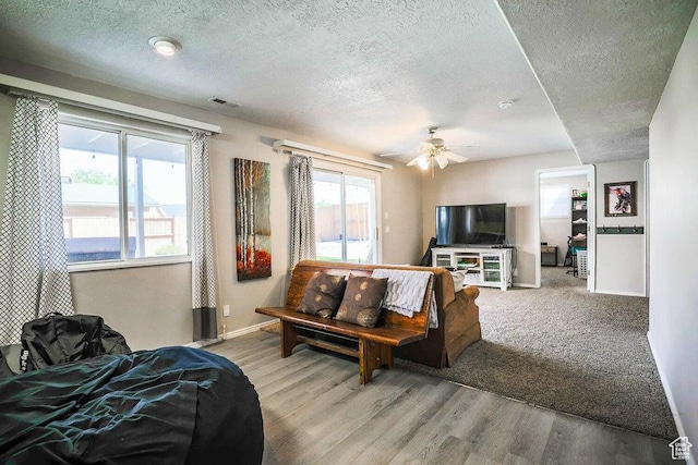 living area featuring visible vents, a textured ceiling, and a wealth of natural light