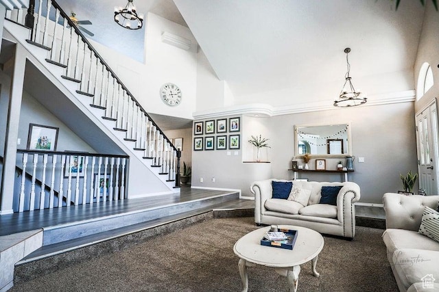 living area with baseboards, stairway, high vaulted ceiling, and an inviting chandelier