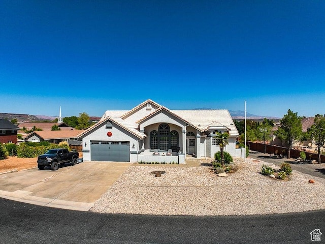 view of front of property featuring a garage, stucco siding, a tiled roof, and driveway
