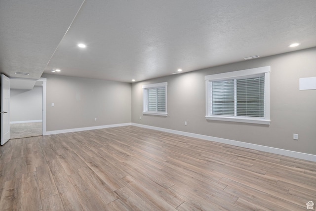 unfurnished room with light wood-style flooring, baseboards, and recessed lighting