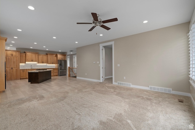 unfurnished living room featuring light carpet, visible vents, recessed lighting, and a ceiling fan