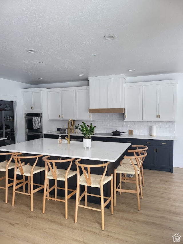 2580 E 279 S, Spanish Fork, UT 84660 - kitchen featuring a kitchen breakfast bar, white cabinetry, and light hardwood / wood-style flooring