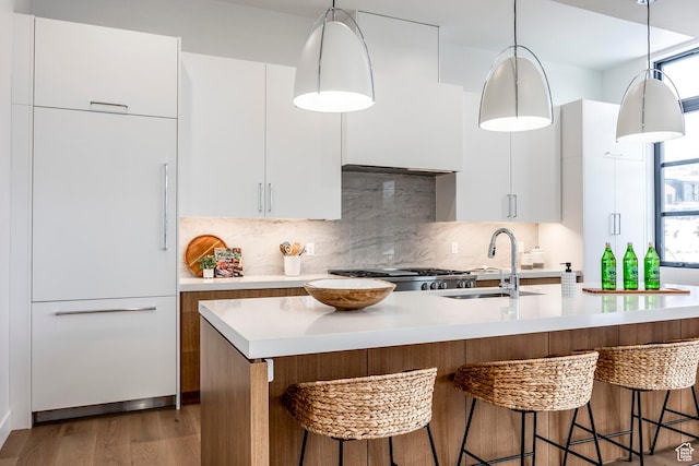 656 N E Capitol St, Salt Lake City, UT 84103 - kitchen featuring modern cabinets, light countertops, dark wood-style flooring, paneled built in refrigerator, and a breakfast bar