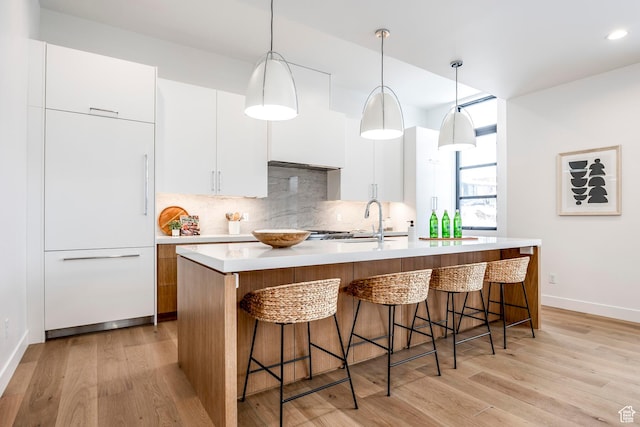 656 N E Capitol St, Salt Lake City, UT 84103 - kitchen with backsplash, light countertops, modern cabinets, light wood-style flooring, and recessed lighting