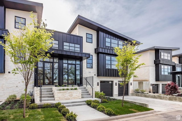 656 N E Capitol St, Salt Lake City, UT 84103 - modern home with an attached garage, driveway, board and batten siding, and stone siding