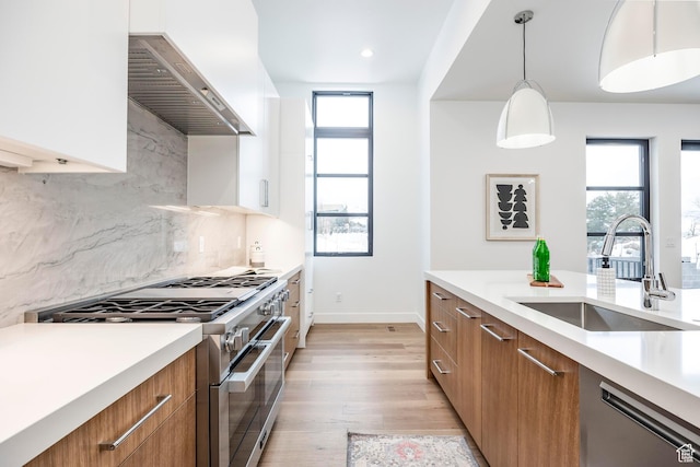 656 N E Capitol St, Salt Lake City, UT 84103 - kitchen featuring appliances with stainless steel finishes, wall chimney exhaust hood, brown cabinetry, modern cabinets, and plenty of natural light