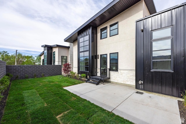 656 N E Capitol St, Salt Lake City, UT 84103 - rear view of house featuring stone siding, a patio, and stucco siding
