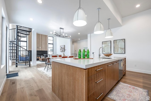656 N E Capitol St, Salt Lake City, UT 84103 - kitchen featuring modern cabinets, a large island with sink, light wood-style floors, light countertops, and hanging light fixtures
