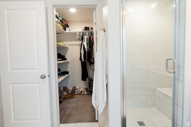 bathroom with a shower with shower door and tile patterned flooring
