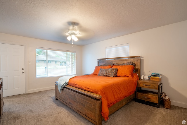 carpeted bedroom with ceiling fan and a textured ceiling