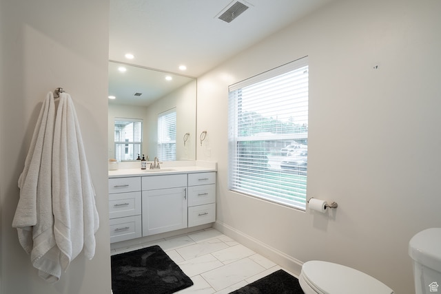 bathroom with vanity, plenty of natural light, and toilet
