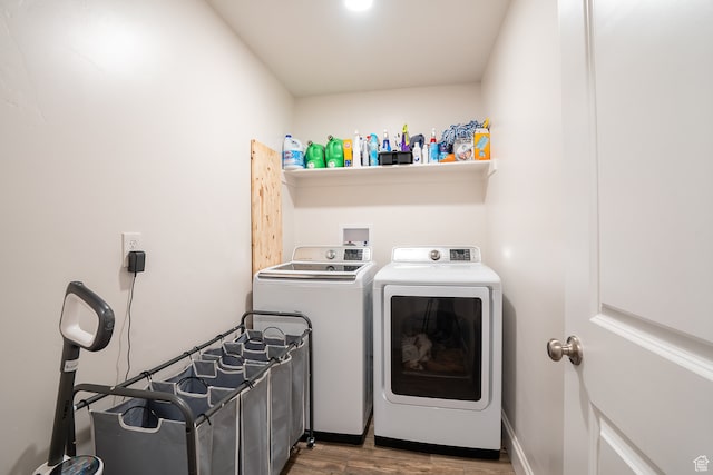 clothes washing area featuring wood-type flooring and independent washer and dryer