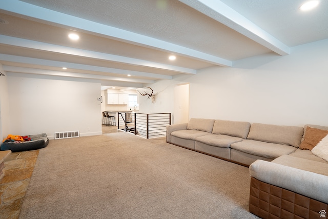carpeted living room with beam ceiling