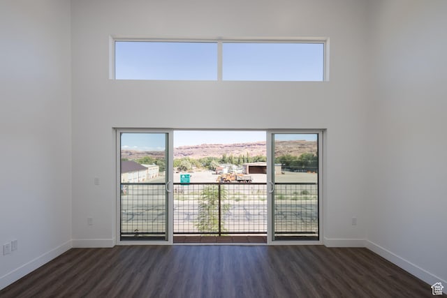 443 W Kane Creek Blvd Unit A204, Moab, UT 84532 - empty room with plenty of natural light, dark wood-style flooring, baseboards, and a towering ceiling