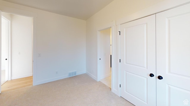 unfurnished bedroom featuring visible vents, baseboards, and light colored carpet