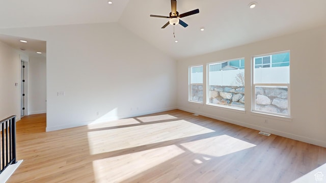 spare room featuring baseboards, visible vents, ceiling fan, vaulted ceiling, and light wood-style floors