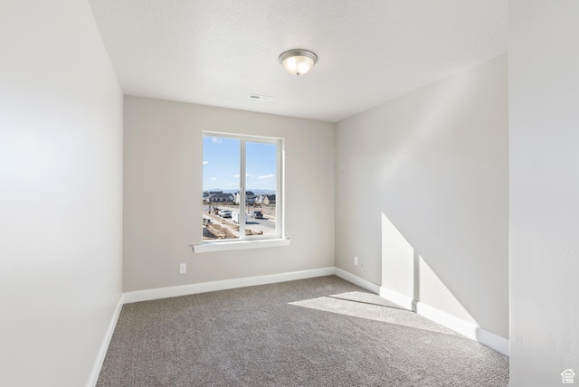carpeted spare room with baseboards