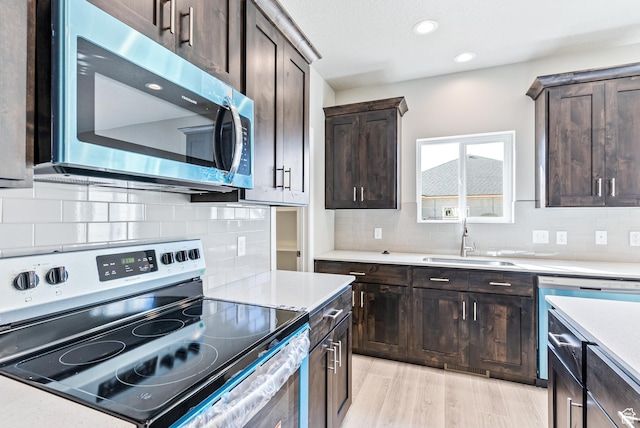 1749 S Sageberry Dr Unit 350, Santaquin, UT 84655 - kitchen with stainless steel appliances, a sink, dark brown cabinets, light countertops, and tasteful backsplash