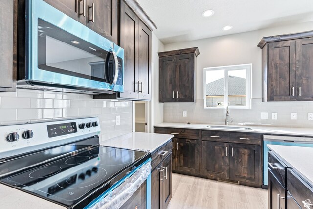 1749 S Sageberry Dr Unit 350, Santaquin, UT 84655 - kitchen with stainless steel appliances, a sink, dark brown cabinets, light countertops, and tasteful backsplash