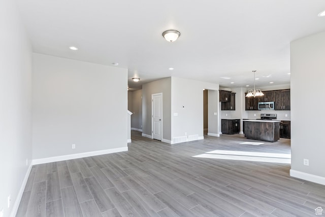 1749 S Sageberry Dr Unit 350, Santaquin, UT 84655 - unfurnished living room with a chandelier, light wood-style floors, baseboards, and recessed lighting