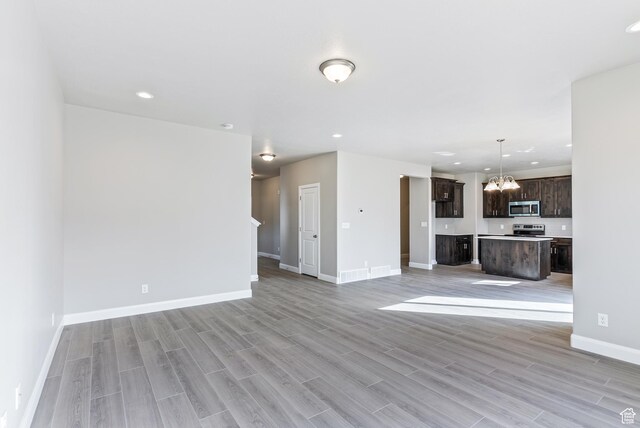 1749 S Sageberry Dr Unit 350, Santaquin, UT 84655 - unfurnished living room with a chandelier, light wood-style floors, baseboards, and recessed lighting
