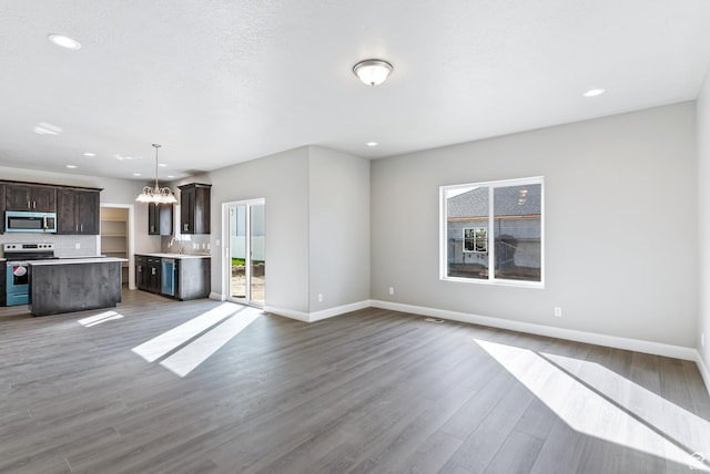 1749 S Sageberry Dr Unit 350, Santaquin, UT 84655 - unfurnished living room featuring a chandelier, healthy amount of natural light, a sink, baseboards, and recessed lighting