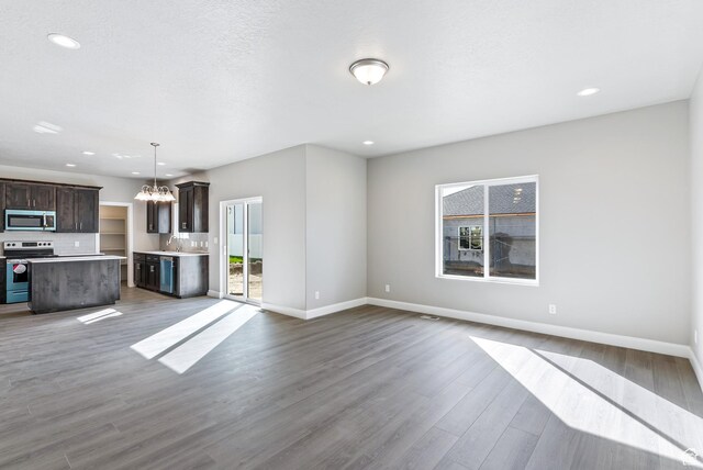 1749 S Sageberry Dr Unit 350, Santaquin, UT 84655 - unfurnished living room featuring a chandelier, healthy amount of natural light, a sink, baseboards, and recessed lighting