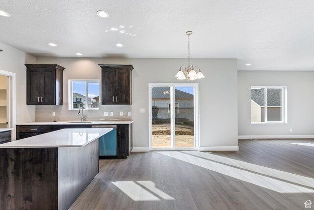 1749 S Sageberry Dr Unit 350, Santaquin, UT 84655 - kitchen with stainless steel dishwasher, a sink, light wood finished floors, dark brown cabinetry, and light countertops