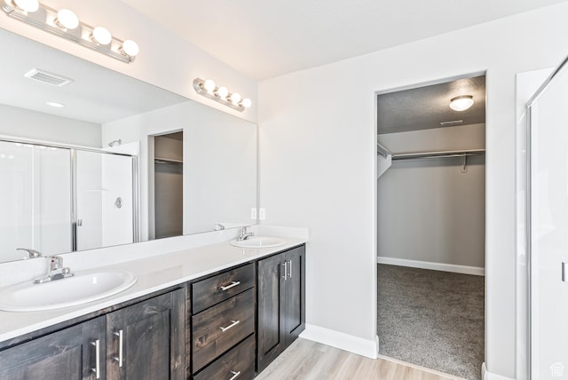 1749 S Sageberry Dr Unit 350, Santaquin, UT 84655 - bathroom featuring a shower stall, double vanity, a spacious closet, baseboards, and wood finished floors