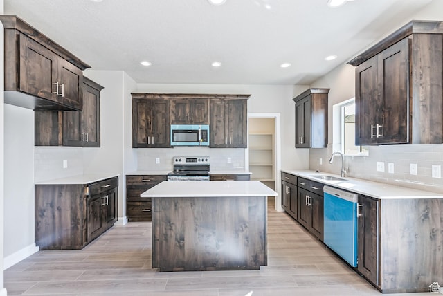 1749 S Sageberry Dr Unit 350, Santaquin, UT 84655 - kitchen with appliances with stainless steel finishes, a sink, dark brown cabinetry, a kitchen island, and light wood-type flooring