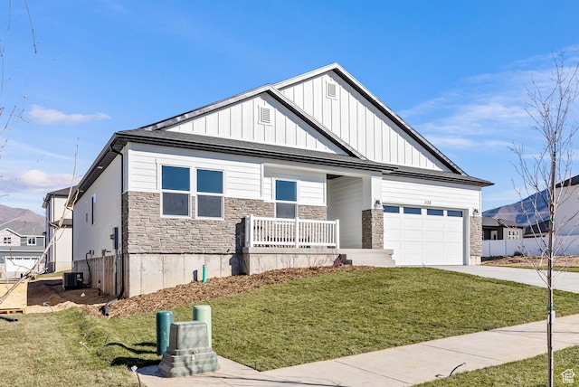 1781 S Windsong Dr Unit 384, Santaquin, UT 84655 - view of front facade featuring concrete driveway, a porch, a garage, board and batten siding, and stone siding