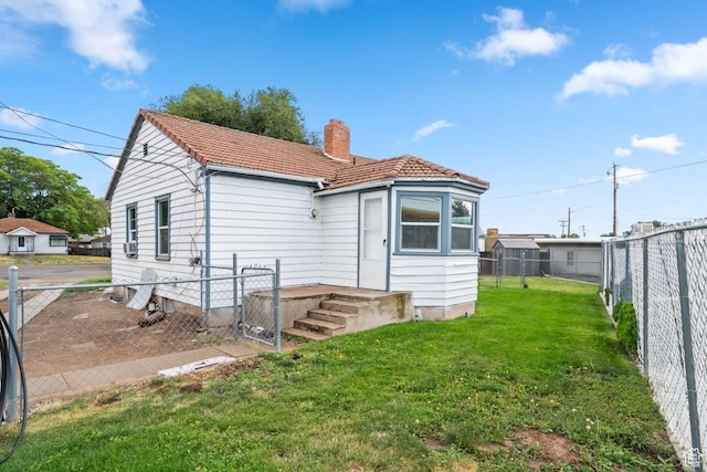 37 N Lakeview Dr, Clearfield, UT 84015 - back of property with a fenced backyard, a lawn, a tile roof, and a chimney