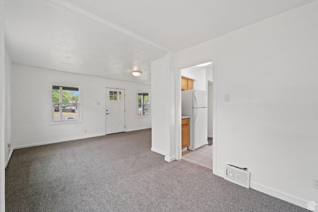 37 N Lakeview Dr, Clearfield, UT 84015 - unfurnished living room featuring baseboards, visible vents, a healthy amount of sunlight, and light colored carpet